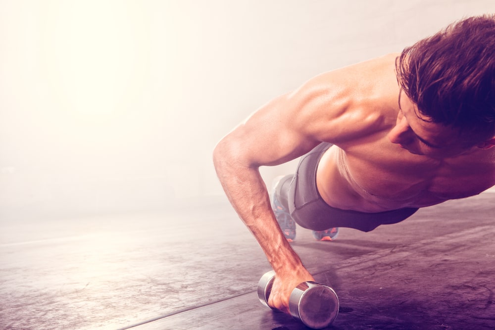 Man doing push-up exercise with dumbbells